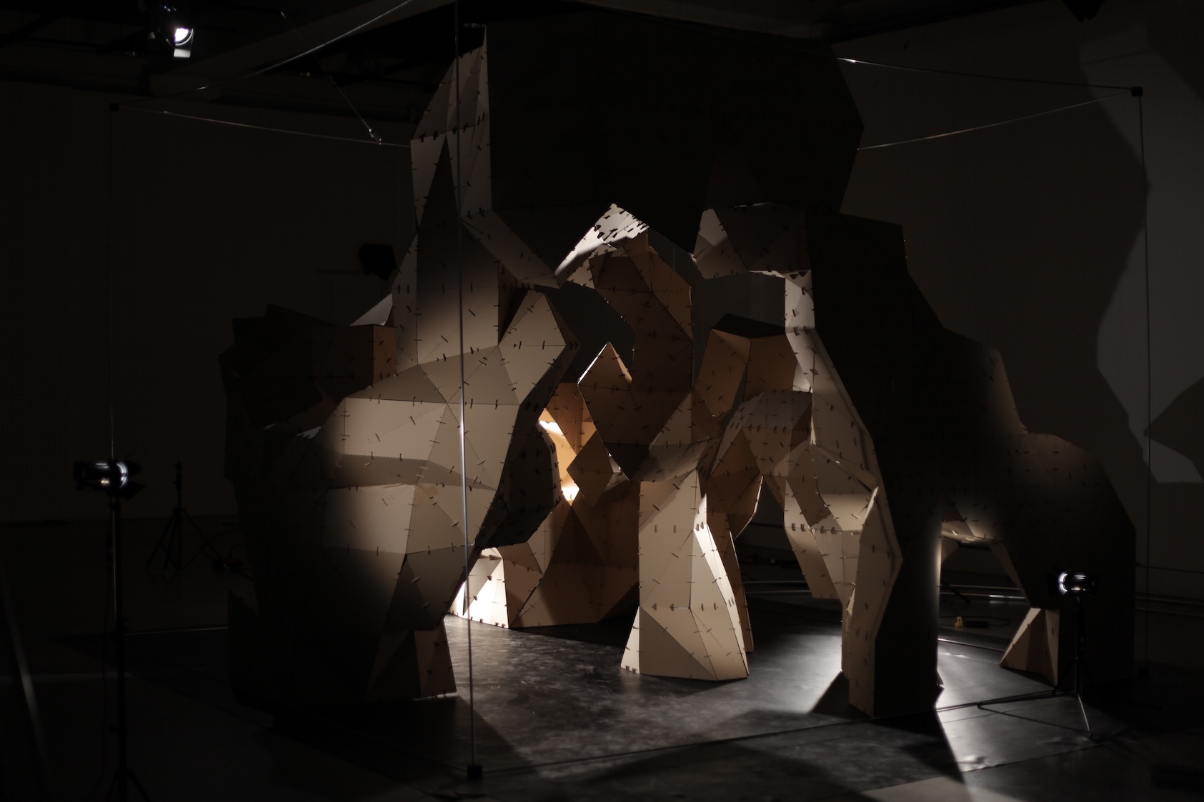 A cardboard three dimensional sculpture within a cubic space