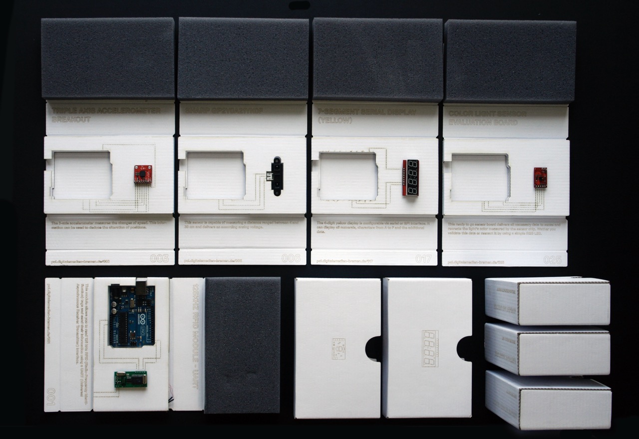 Topview of many lasercut cardboard boxes containing electronic components like an arduino